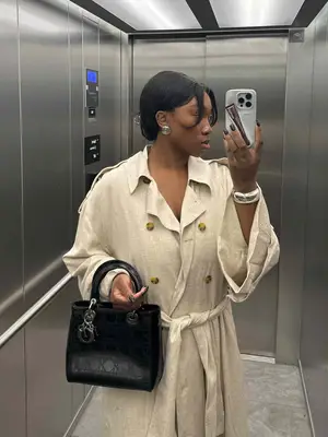Nnenna Echem wears a lightweight trench coat and black handbag