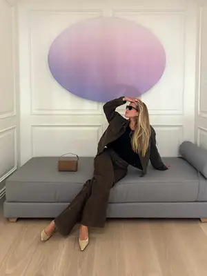 Sofia Richie Grainge wears a brown utility jacket and pants, black top, sunglasses, and nude heels