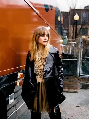 Suki Waterhouse wears a tailored cropped leather trench coat, fringe embroidered top, and leather pants