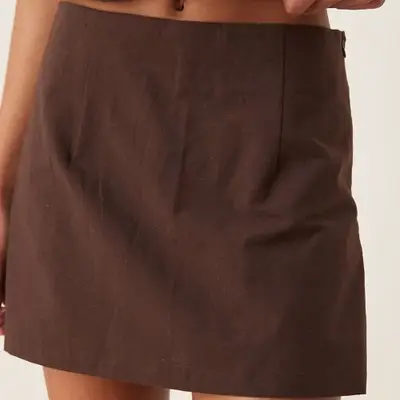 Model is wearing a brown linen skort 