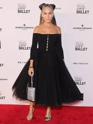 Sarah Jessica Parker wearing an off-the-shoulder black dress with tulle skirt and oversized hair bow