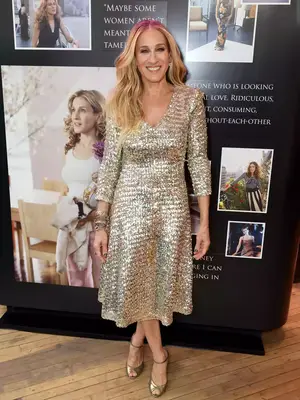 Sarah Jessica Parker wearing a metallic gold midi dress with gold heels