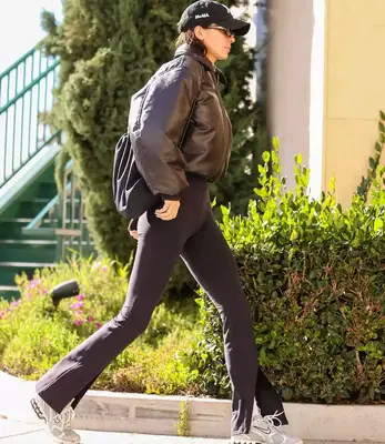 Kendall Jenner wearing yoga pants, sneakers, a bomber jacket, and hat