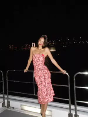 Olivia Rodrigo wearing a red and white heart dress and black shoes