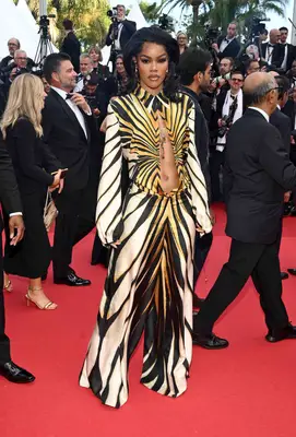 Teyana Taylor wears a striped Roberto Cavalli jumpsuit with vertical torso cutout to the Megalopolis premiere at Cannes 2024