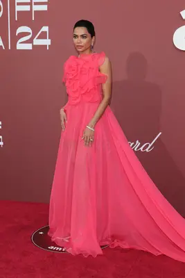Mona Patel wears a hot pink ruffled sheer gown and decadent jewelry to the Cannes 2024 amfAR Gala