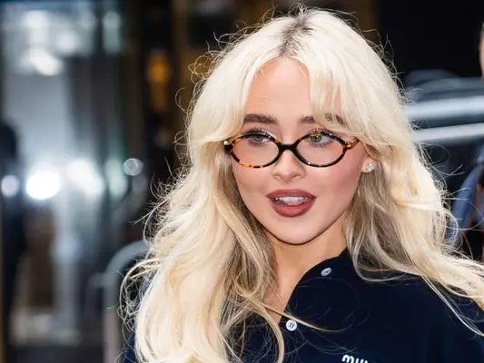 Sabrina Carpenter wearing miu miu navy polo with tortoiseshell oval eyeglasses