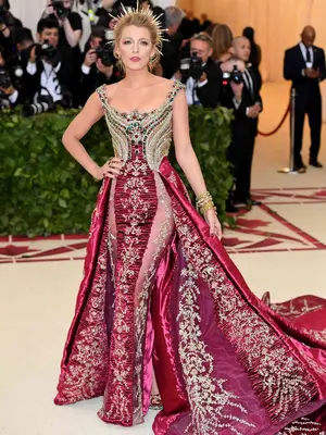 Blake Lively wears a crimson and gold Versace gown and headpiece to the 2018 Met Gala