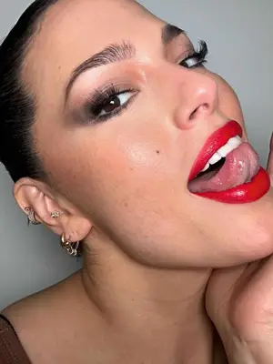 Close-up of Ashley Graham posing with a classic glam makeup look and mixed metals earrings