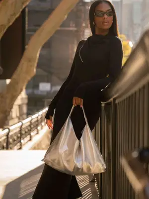 model holding slouchy silver handbag