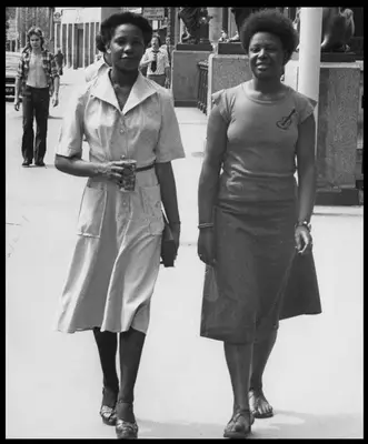 Two women wearing shirt dresses