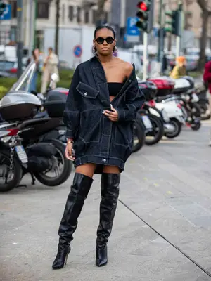 Didi Stone wearing oversized black denim jacket, thigh-high boots, and round sunglasses