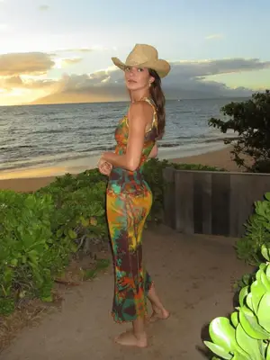 Beyonce wears a red turtleneck, leather trench coat, cowboy hat, and lipstick