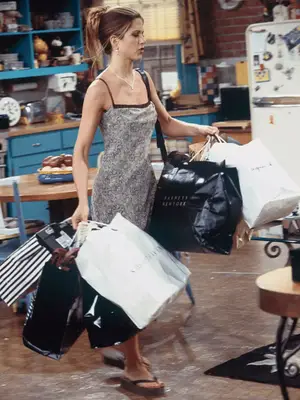 Jennifer Aniston wearing a print slip dress and carrying shopping bags
