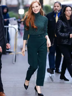 A model is wearing a beige crew neck knit sweater 