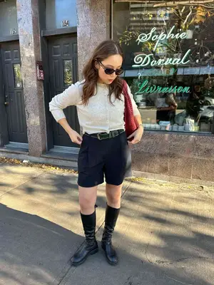 A side profile of a black heeled shoe with a silver jewel on the toe and a black jeweled heeled. 