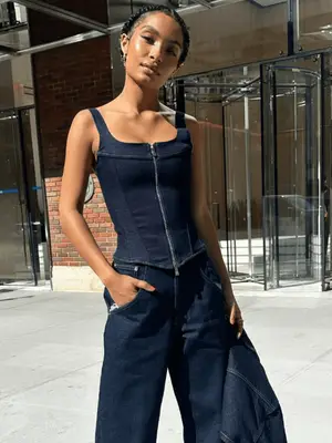 Yara Shahidi wears dark wash denim corset top, jacket, and jeans