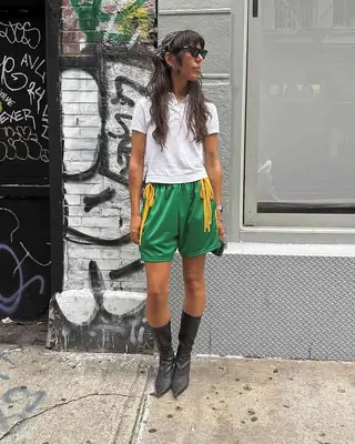 A girl wearing athletic shorts and a polo shirt. 