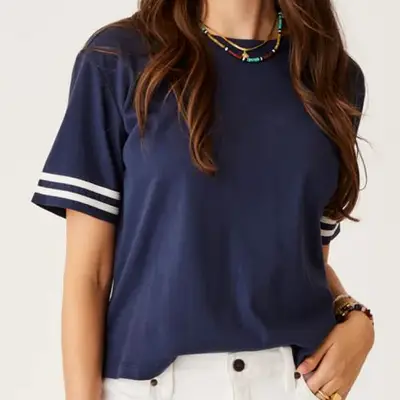 model wearing navy blue boxy tee with white stripes on sleeves