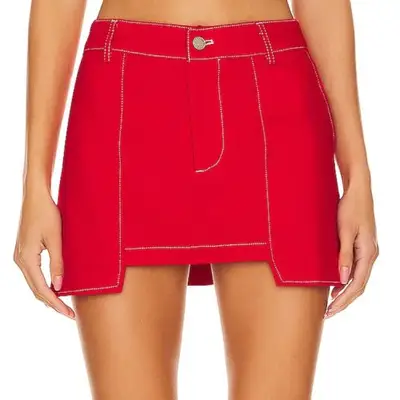 model wearing red mini skirt against plain background