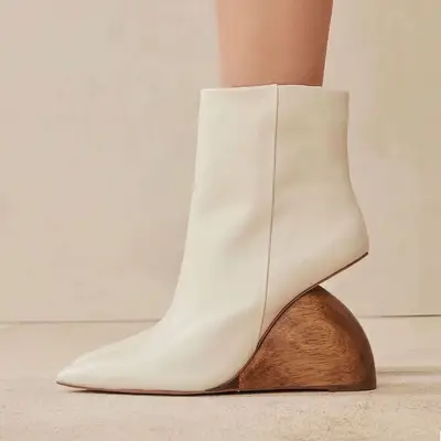 Close-up of white Cult Gaia ankle boots with architectural wooden wedge heel