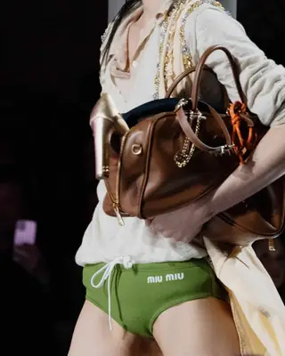 Miu Miu model carrying an overstuffed bag