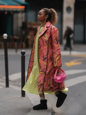 Petra Henriette Rufi wearing a patterned overcoat with a lime green long dress and black short uggs.