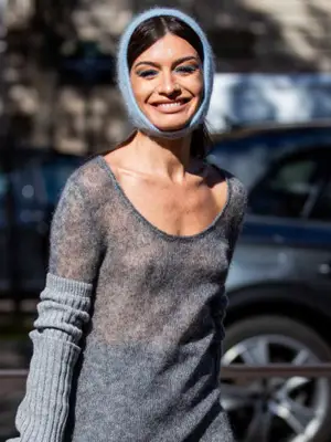 Woman wearing sheer sweater, arm warmers, and head scarf