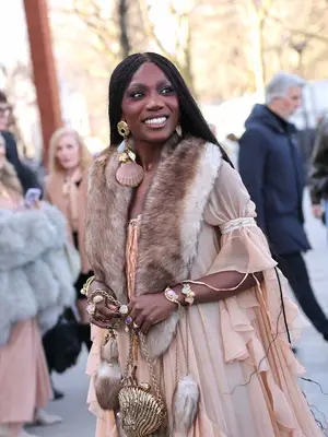Doechii wears a fur scarf, sheer peach dress, and lots of accessories 
