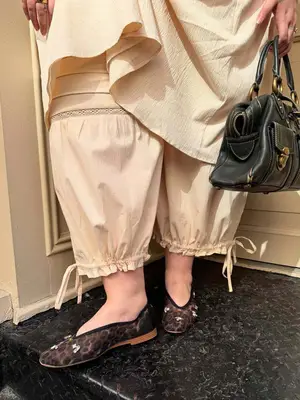 Abby Bible wearing cream bloomers with leopard flats and leather handbag