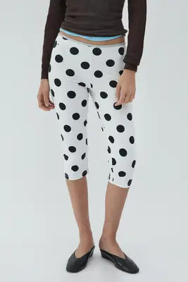 Abisola Omole wearing a white top a black lacy skirt, and black kitten heels with buckle