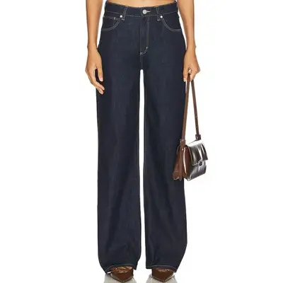 Abrand 95 Baggy Wide Leg Jeans in dark wash on model styled with brown handbag and shoes