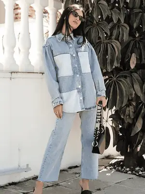 Abby Bible wears a dark wash denim jacket and jeans with vintage brown shoulder bag, red lens sunglasses, and black glove flats