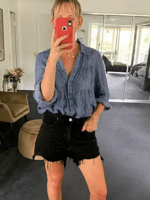 Tashiya Rajasingham wears a white tank top, jeans, and denim jacket with neutral handbag, sneakers, and minimal jewelry