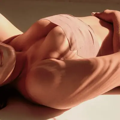A woman wearing boob tape while laying down
