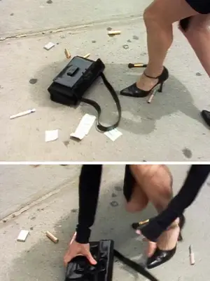 Close-up of Carrie Bradshaw picking up scattered items, including a handbag, while wearing black pumps