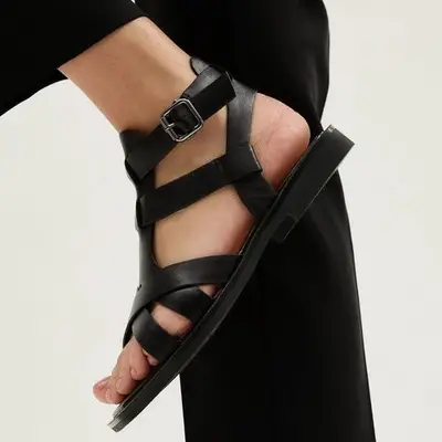 Lonza Sierra black gladiator sandals on model styled with black trousers