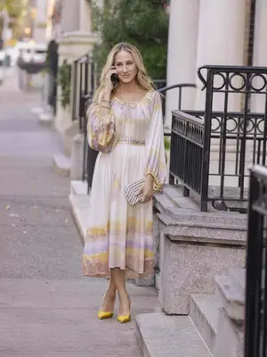 Sarah Jessica Parker wears a colorful sundress and yellow satin pumps