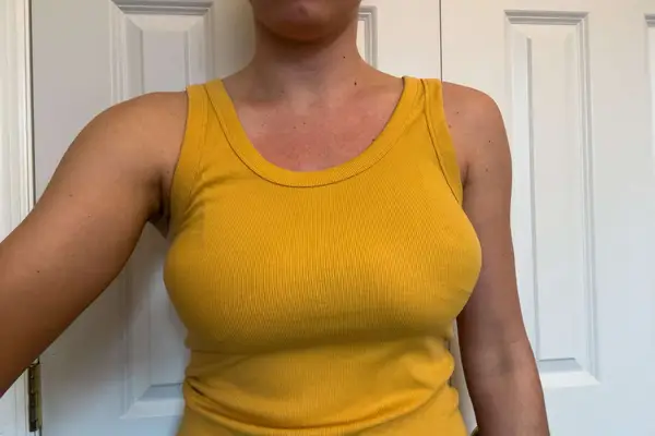 A person wears Nue Breast Tape under a tank top