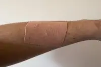 A piece of Nue Breast Tape is applied to a person