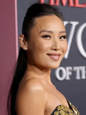 Li Jun Li smiling at camera wearing silver diamond huggie earrings