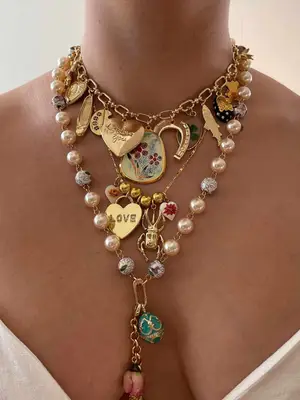 model wearing multiple gold layered charm necklaces