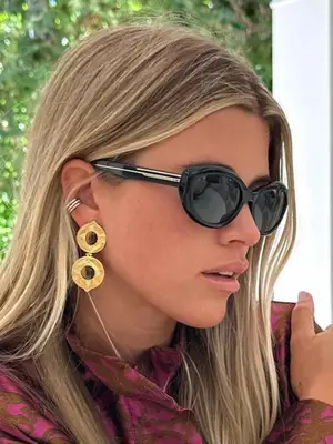 Sofia Richie Grainge wearing black sunglasses, gold earrings, and silver ear cuff