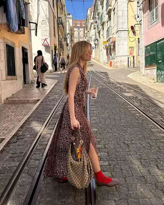 A woman holding a bag with charms. 