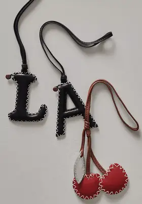Leather bag charms shaped to say 