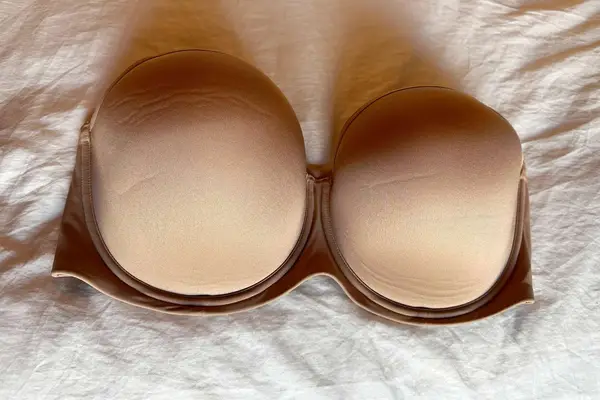 Spanx Up For Anything Strapless Bra displayed on a white sheet