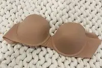 Spanx Up For Anything Strapless Bra displayed on a chunky knit blanket