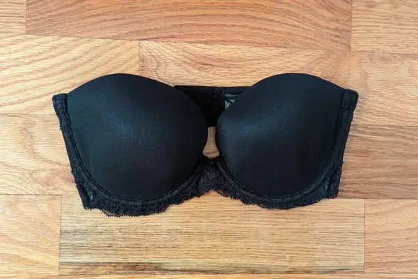 Natori Feathers Strapless Bra displayed on a wooden floor 