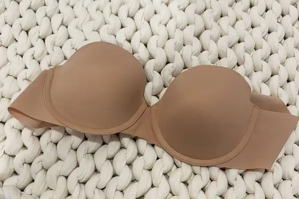 Spanx Up For Anything Strapless Bra displayed on a chunky knit blanket