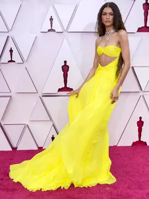 Zendaya wears a yellow Valentino gown with midriff cutout to the 2021 Oscars